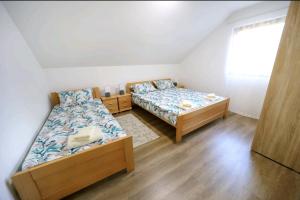 索科矿泉村Apartman Luki的一间卧室设有两张床和窗户。