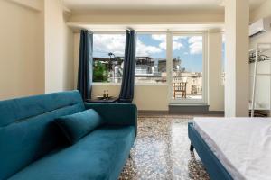 雅典ATHENS COMMERCIAL的客厅设有蓝色的沙发和大窗户
