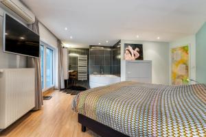 布鲁日Huis @ Sint Kruis的一间卧室配有一张床,浴室设有浴缸
