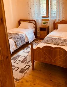 BogëPaja Guesthouse - Camping的一间带两张床的卧室和地毯