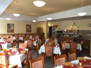 弗兰季谢克矿泉镇LD PALACE Spa & Kur的一间设有白色桌椅的用餐室