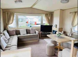 卡纳芬Beautiful 3 bed Static Caravan with Snowdon views in Caernarfon的客厅配有沙发和桌子