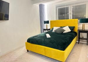 伦敦Bella-Ruiz Home for Your Perfect Staycation的一张黄色的床,配有绿毯和枕头
