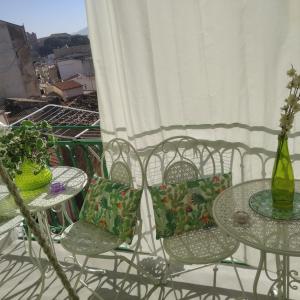 巴勒莫Casa Amari alla Zisa HOSTEL的两把桌子和椅子,位于带鲜花的阳台