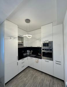 蒂瓦特Vila Jovanka的白色的厨房配有白色橱柜和电器