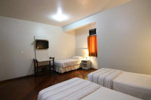 贝廷Samba Betim的酒店客房设有两张床和电视。