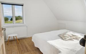 班霍尔姆Awesome Home In Bandholm With House Sea View的白色的卧室设有床和窗户