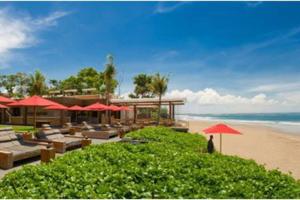 塞米亚克Yoga Villa的海滩上带椅子和遮阳伞的度假村