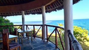 ShimoniRoom in Villa - 38m2 Turtle Suite in a 560 m2 Villa, Indian Ocean View的一个带椅子的门廊,享有海景