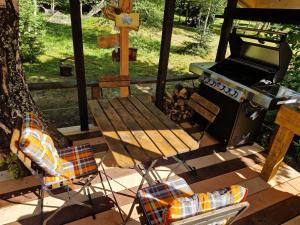 斯托拉Glamping Štôla- Symbioza的天井上的野餐桌、烧烤架和椅子