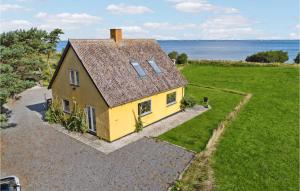 班霍尔姆Awesome Home In Bandholm With House Sea View的享有黄色房子的空中景色,背景是大海