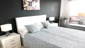 科斯塔卡玛Top Cocoon Powered by SolymarCalma的卧室配有白色的床和两盏灯。