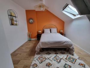 索米尔Superbe duplex La Verrière chic, cosy et spacieux的一间卧室配有一张橙色墙壁的床