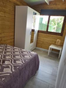 吉亚德伊索拉Preciosa cabaña的一间卧室配有一张床、一张桌子和一个窗户。