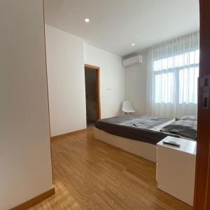 布拉加Apartamento em braga的一间卧室设有一张大床和一个大窗户