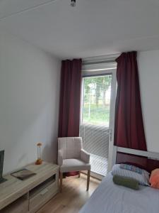 阿姆斯特丹Dubbelink 3A的卧室配有床、椅子和窗户。