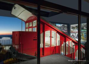 比尔根山Bürgenstock Hotel & Alpine Spa的红色火车,在一座带窗户的建筑里