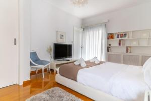 雅典The HostMaster Luminous Elite Estate的一间白色卧室,配有一张大床和一台电视
