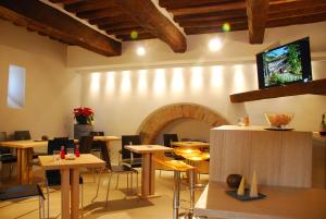 古比奥Coldimolino Resort的一间带桌椅和壁炉的餐厅