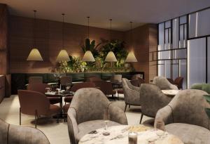 伊斯坦布尔亚洲迪万伊斯坦布尔酒店的一间设有桌椅的餐厅,种植了植物