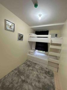 马尼拉Condo in Ortigas (Kimea Suite)的一间设有两张双层床和地毯的房间