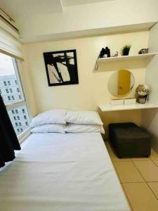 马尼拉Condo in Ortigas (Kimea Suite)的卧室配有白色的床和镜子