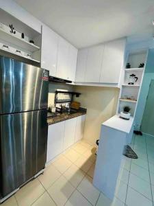 马尼拉Condo in Ortigas (Kimea Suite)的厨房配有不锈钢冰箱和白色橱柜