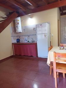 伊瓜苏港Alojamiento céntrico florida的厨房配有桌子和白色冰箱。