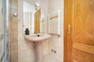波苏埃洛-德阿拉尔孔Casa Grande CASA CAFE MADRID 22 PERSONAS的浴室配有盥洗盆和带镜子的淋浴