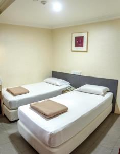 新加坡Amrise Hotel的一间房间,有三张床