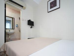 新加坡Amrise Hotel的白色的客房设有床和水槽