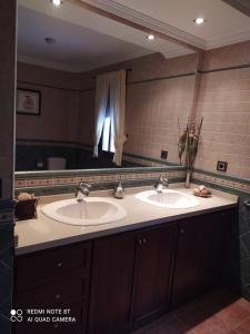 阿尔科斯-德拉弗龙特拉Las Vistas的一间带两个盥洗盆和大镜子的浴室