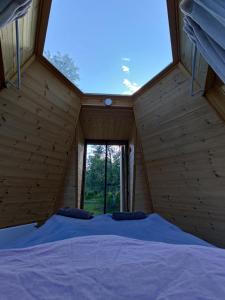 基律纳Aurora Cone的木制客房的一张床铺,设有大窗户