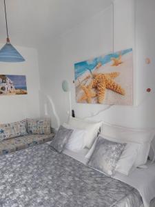 纳克索乔拉Doron Hotel Delfini的一间卧室配有床、沙发和绘画