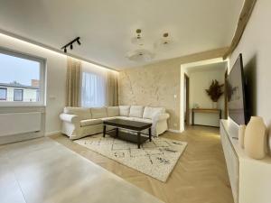 尤斯托尼莫斯基BALi 22的客厅配有白色的沙发和桌子
