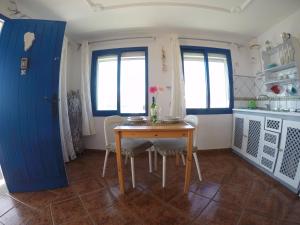 普拉亚格马达本塔纳斯兰萨罗特公寓的厨房配有桌椅和蓝色的门