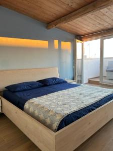 圣卢奇多B&B Casa CamiLory的一间卧室配有一张带蓝色床单的床和一扇窗户。