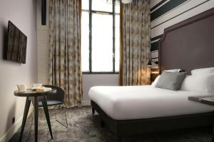 巴黎法布里克酒店的酒店客房设有一张床和一张小桌子。