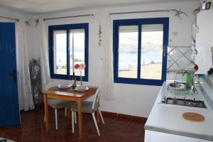 普拉亚格马达本塔纳斯兰萨罗特公寓的厨房配有桌子、炉灶和窗户。