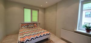 考纳斯ŠILAINIŲ APARTAMENTAI的卧室配有床,位于带2个窗户的房间
