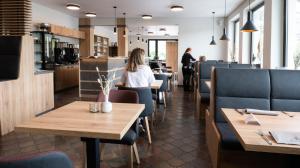锡默拉特帕鲁舍弗酒店的餐厅设有木桌和蓝色椅子