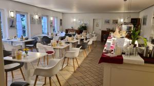 洛布Ferienwohnungen Moenchgut und Ruegen的一间设有白色桌子和白色椅子的餐厅