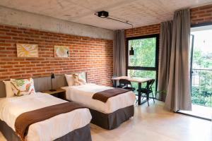 布宜诺斯艾利斯H5063的一间卧室设有两张床和砖墙