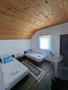 萨拉热窝Holiday Home DMD Sarajevo的一间卧室设有两张床和木制天花板