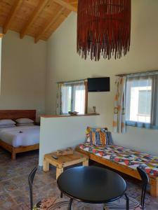 El GansoPension Gabino (rooms)的客房设有两张床、一张桌子和一张沙发。