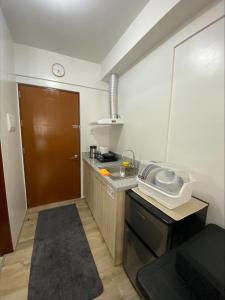巴科洛德MesaVirre Garden Residences Unit 402的一个带水槽和棕色门的小厨房