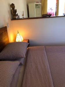 El GansoPension Gabino (rooms)的一间卧室设有两张床和一张桌子上的台灯。
