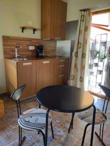 El GansoPension Gabino (rooms)的厨房配有桌子、两把椅子和一张桌子