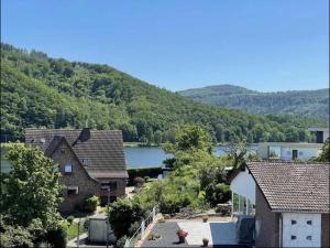 ObermaubachGreen Seeblick Hostel und Apartments am See的享有湖景和山景度假屋的景致。