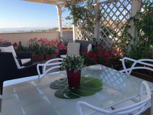 卡尔塔吉罗Attico Da Rosa con vista spettacolare a 360 gradi的鲜花庭院里的白色桌子和椅子